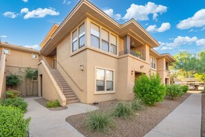 A two-story residential building with a balcony, a staircase, and a landscaped front yard. - Gated Condo Near Grayhawk Golf & Kierland (Scottsdale)