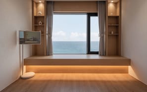 A room with a large window, wooden flooring, built-in shelves, and a television. - Hound Steelcove Gyeongju Gampo (Gyeongju)