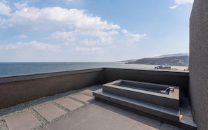 A rooftop terrace with a hot tub, a clear view of the sea, and a distant shoreline. - Hound Steelcove Gyeongju Gampo (Gyeongju)