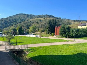 Ländliche Landschaft mit einer Straße, einer Brücke und einem Hügel im Hintergrund.