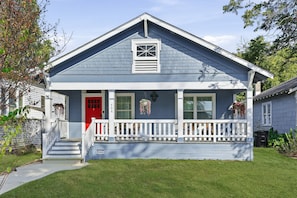 A two-story house with a red door, a white porch, and a mailbox. - Starry Night - A Birdy Vacation Rental (San Antonio)