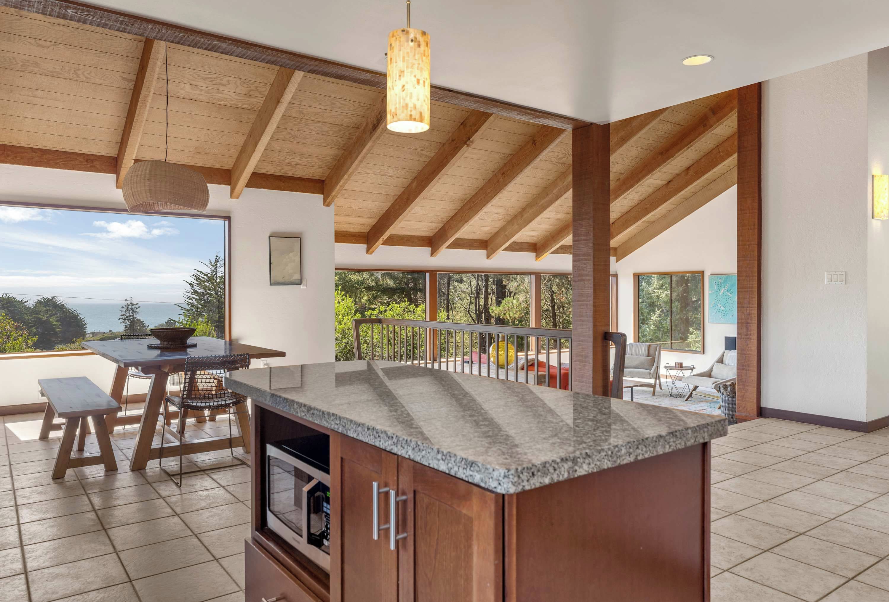 Una cocina amplia con una isla grande, vigas de madera y vistas al exterior.