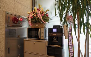 Una cuina americana equipada amb cafetera, microones i nevera petita.