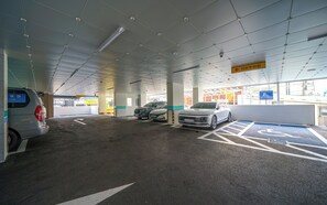 Un aparcament públic amb diverses places, algunes senyalitzades per a persones amb discapacitat, i un camí clar cap a la sortida.