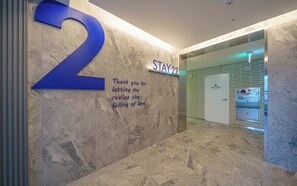 A hallway with a large '2' sign, a 'STAY 22' sign, and a 'STAFF ONLY' door. - Stay 22 Hotel Daegu Innovation City (Daegu)