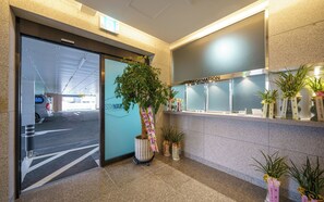 A reception area with a glass door entrance, a reception desk, and potted plants. - Stay 22 Hotel Daegu Innovation City (Daegu)