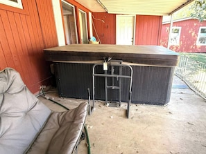 A room with a large black sofa, a small table, and a metal ladder.