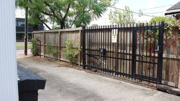 A gated property with a wooden fence and a black metal gate.