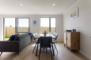 Un espace repas moderne avec une table en bois, des chaises et un canapé.