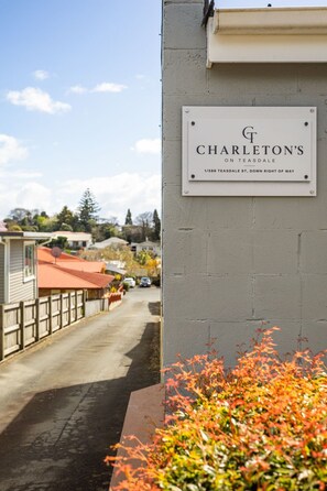 A sign for CHARLETON'S ON TEASDALE, indicating the address 1/588 TEASDALE ST, DOWN RIGHT OF WAY.