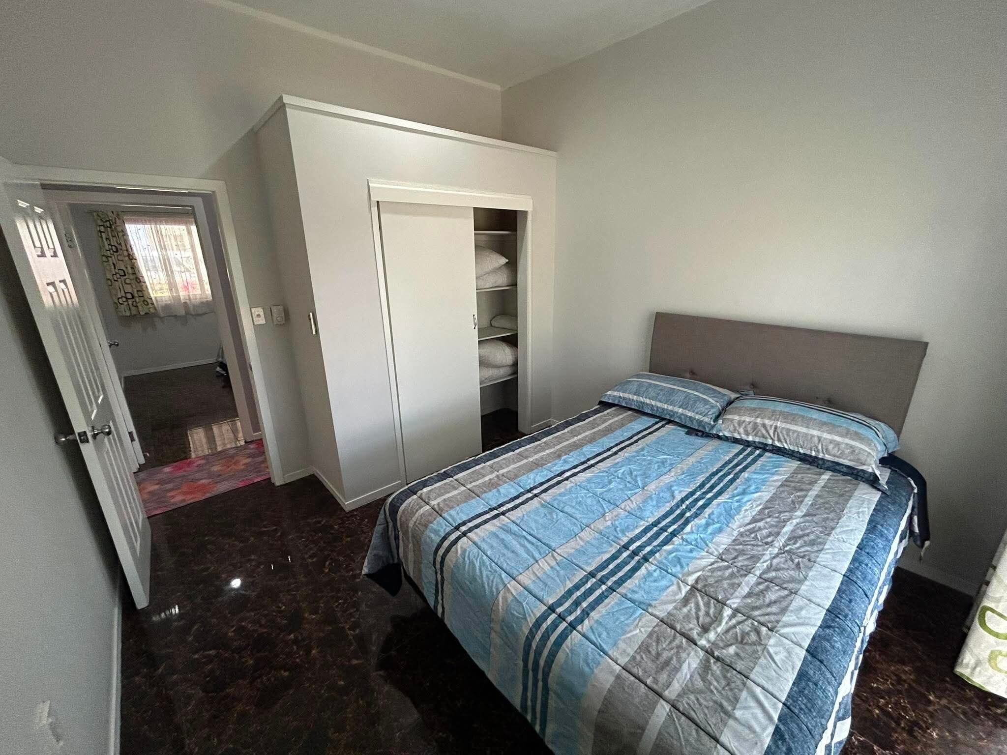 A bedroom with a bed, a wardrobe, and a closet.