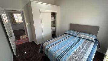 A bedroom with a bed, a wardrobe, and a closet.