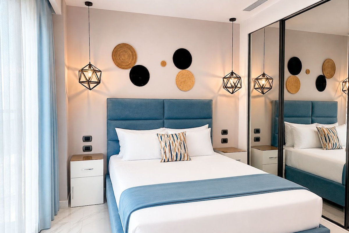 A modern bedroom with a large bed, bedside tables, and a mirror.