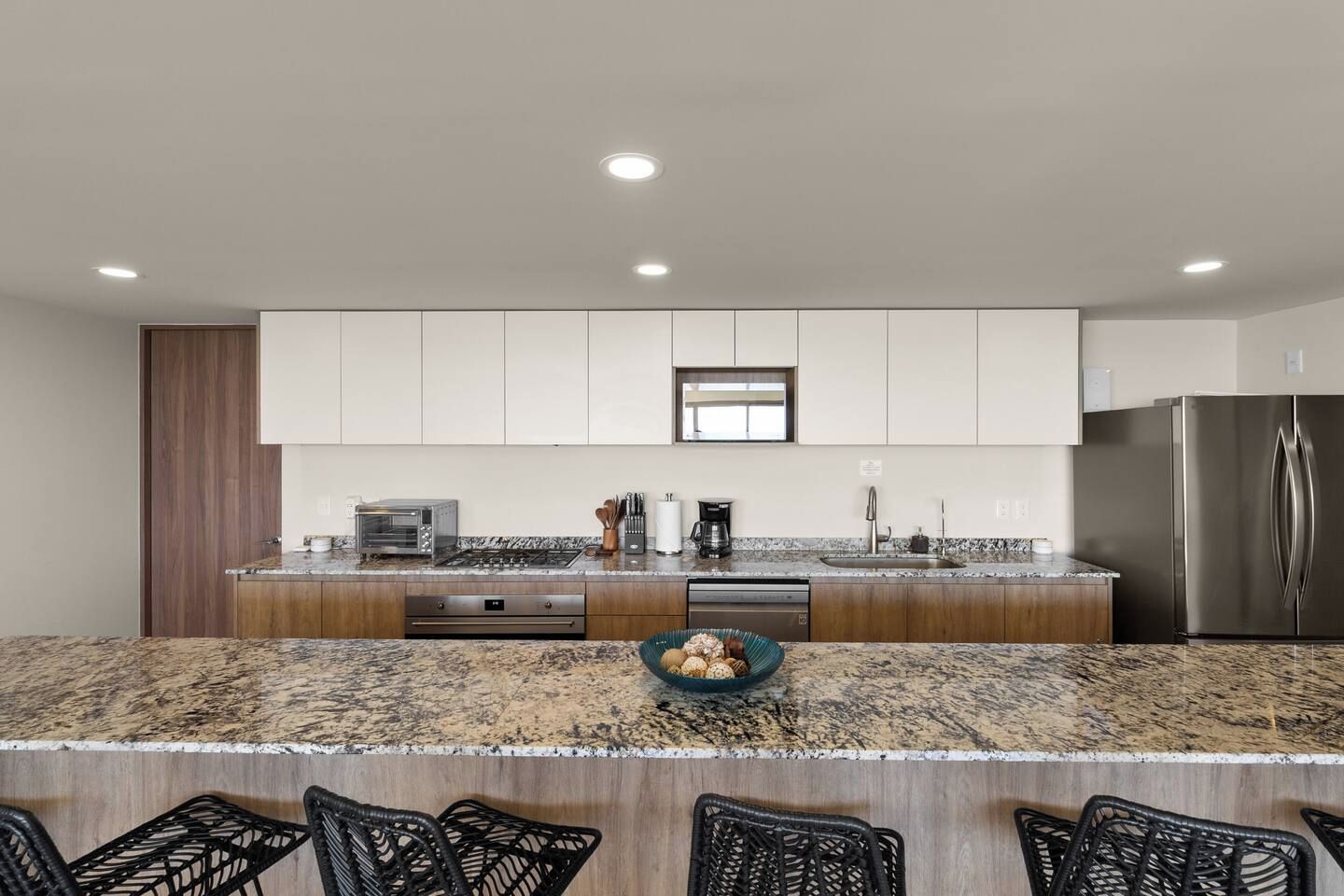 A modern kitchen with a granite countertop, stainless steel appliances, and a built-in oven.