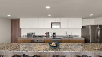 A modern kitchen with a granite countertop, stainless steel appliances, and a built-in oven.