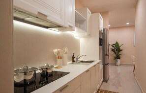 A modern kitchen with a built-in stove, a refrigerator, and a sink. - Tresor Apartments by Veluxe Stay (Xom Chieu)
