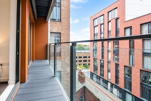 Ein modernes Gebäude mit einem Glasbalkon mit Blick auf eine Parkgarage.
