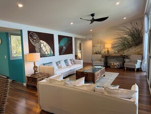A living room with a white sofa, a coffee table, striped chairs, and artwork on the wall. - Relaxing getaway with the family  on the water. (South Stradbroke)