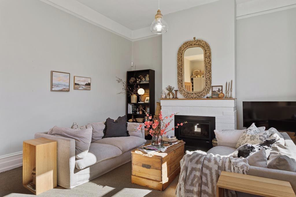 A living room with a fireplace, a sofa, a coffee table, and a bookshelf.