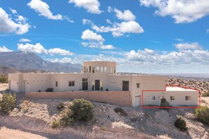 Un bâtiment à deux étages, doté d’un toit plat, de nombreuses fenêtres et d’une allée pavée.