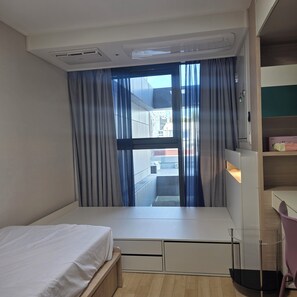 Una camera da letto moderna con un letto, una scrivania e vista all'esterno.