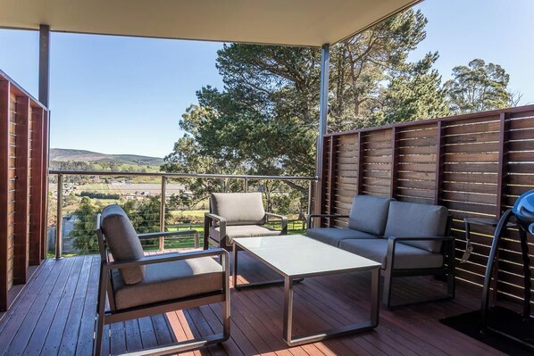 A covered outdoor seating area with a view of the landscape.