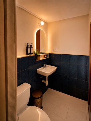 A bathroom with a toilet, sink, and mirror. - Hotel Colonial Cusco (Wanchag)