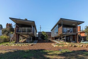 A modern two-story house with a covered front porch and a landscaped backyard.