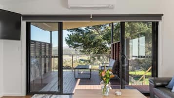 Un saló modern amb una porta corredissa de vidre que dona a una terrassa exterior.