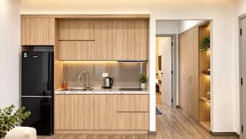Une cuisine moderne avec des meubles en bois, un réfrigérateur noir et un four encastré.