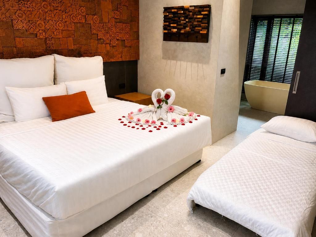 Habitación de hotel con una cama grande, una cama más pequeña, un revestimiento de madera en la pared, una obra de arte colgada en la pared y una bañera.