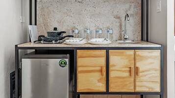 A compact kitchen with a microwave, refrigerator, sink, and wooden cabinets.