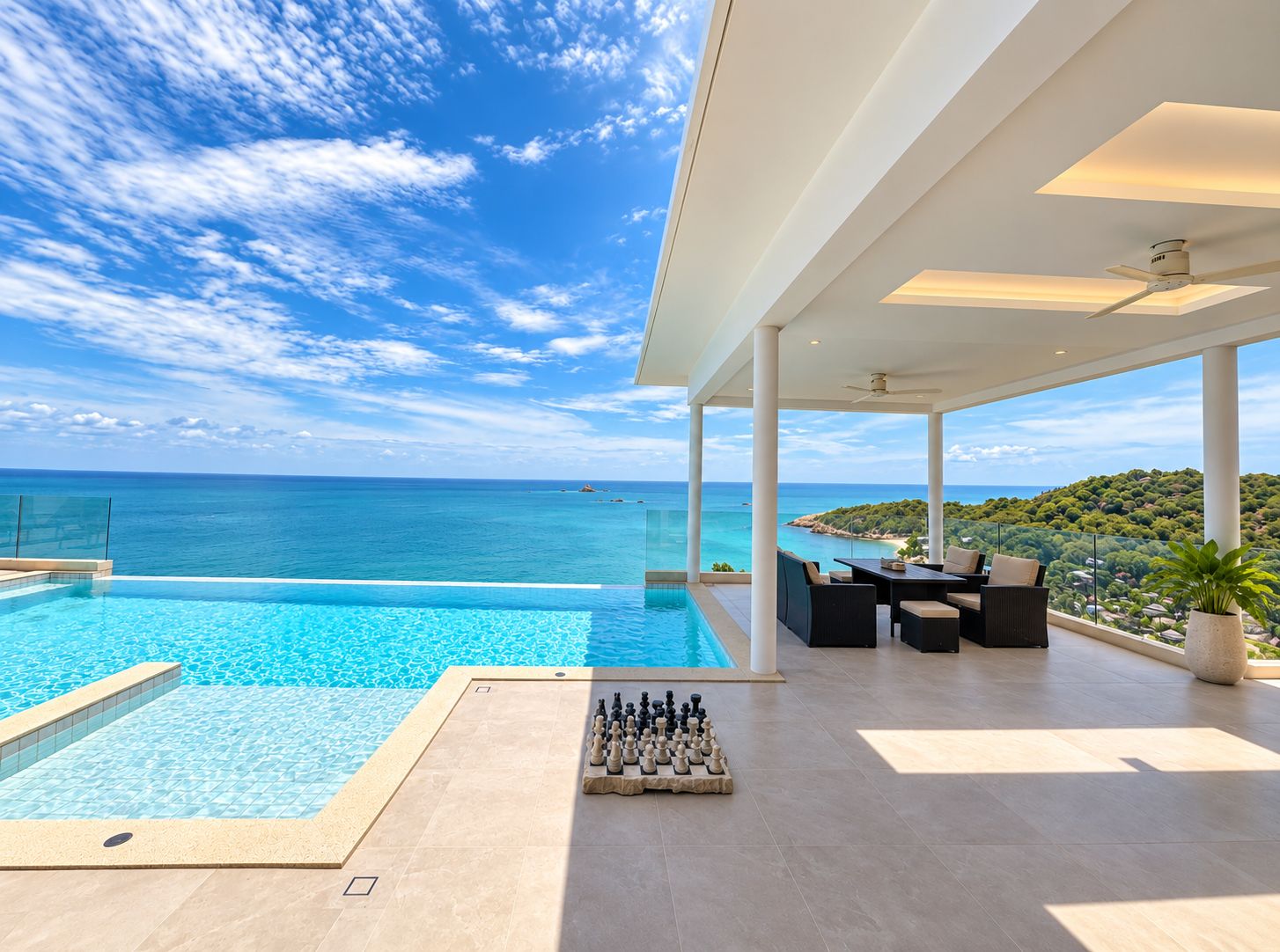 Une piscine avec un jeu d’échecs, des sièges extérieurs et une vue sur la mer.