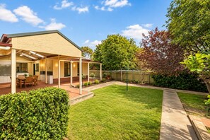 A residential property with a covered patio, a lawn, and a fenced backyard. - Spacious 3-Bedroom Marion Home | Alfresco Living | Table Tennis (Marion)