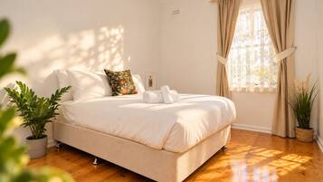 Une chambre à coucher avec un lit, une fenêtre avec des rideaux et une plante en pot.