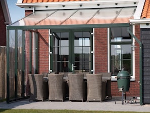 A patio area with wicker furniture and a grill. - Luxury villa with private wellness (Colijnsplaat)