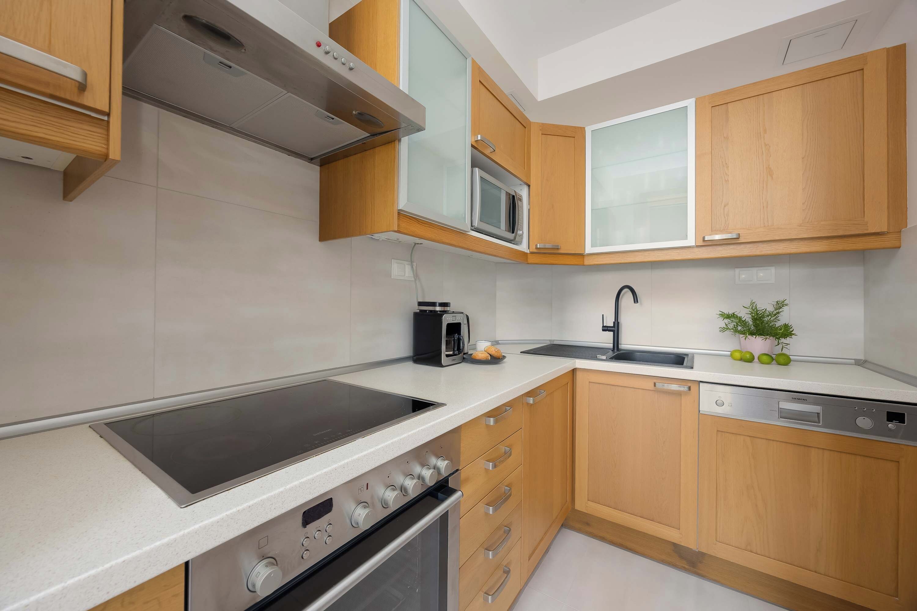 A modern kitchen with a built-in stove, microwave, and dishwasher.