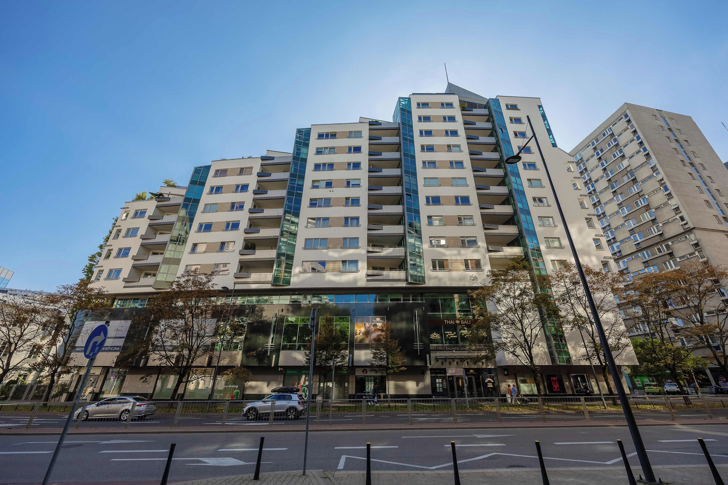 A multi-story residential building with balconies and a glass facade.