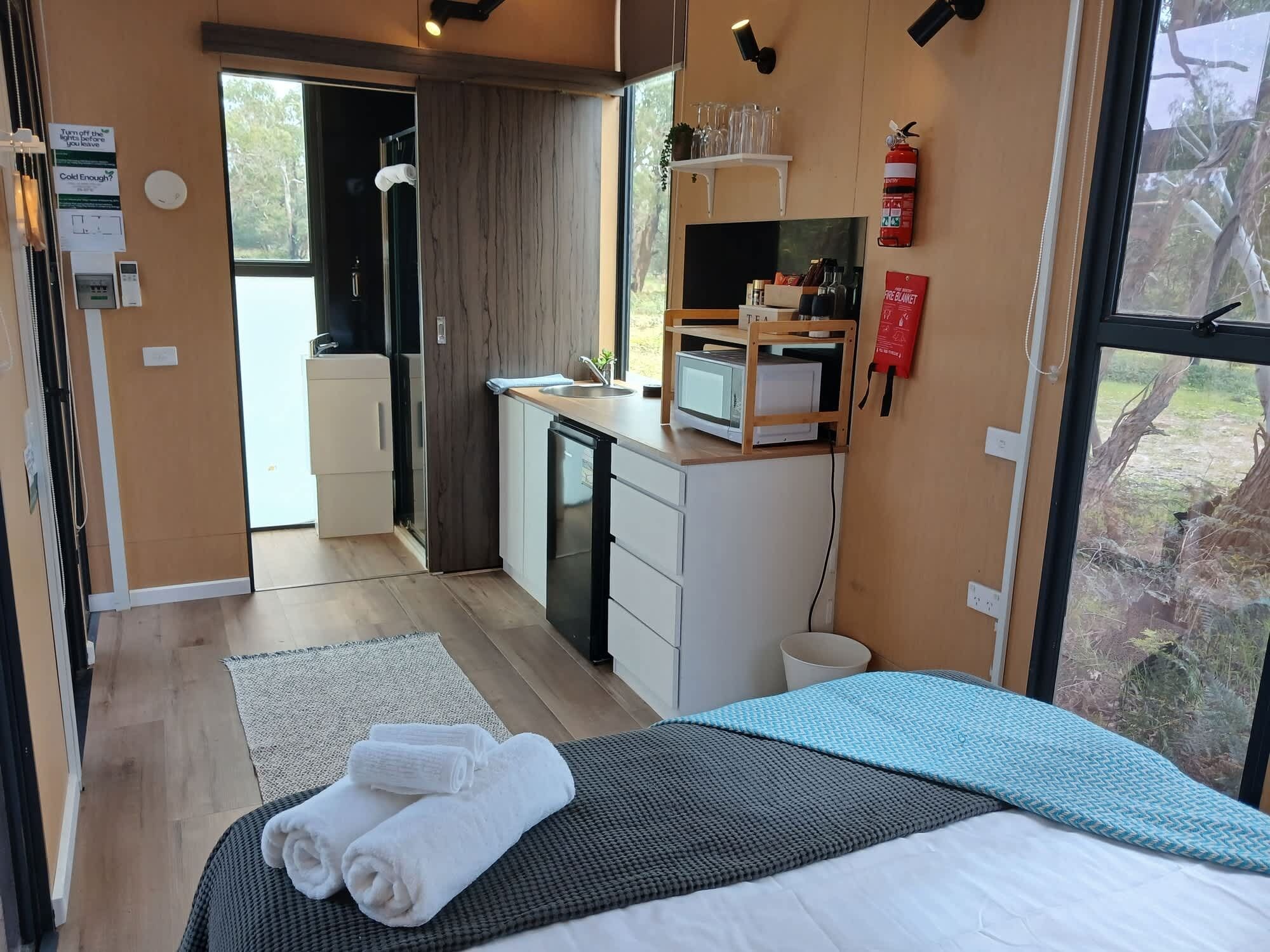 Une petite chambre comprenant un lit, une kitchenette et une salle de bain.