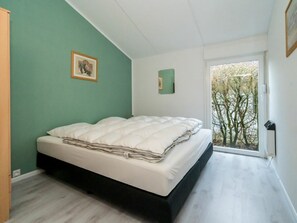 A bedroom with a bed, a window, and a view of trees. - Holiday Home in Renesse With Swimming Pool (Renesse)
