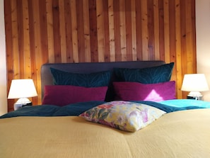 A bed with a wooden headboard, two bedside lamps, and multiple pillows. - Forester's House at Linowsee (Rheinsberg)
