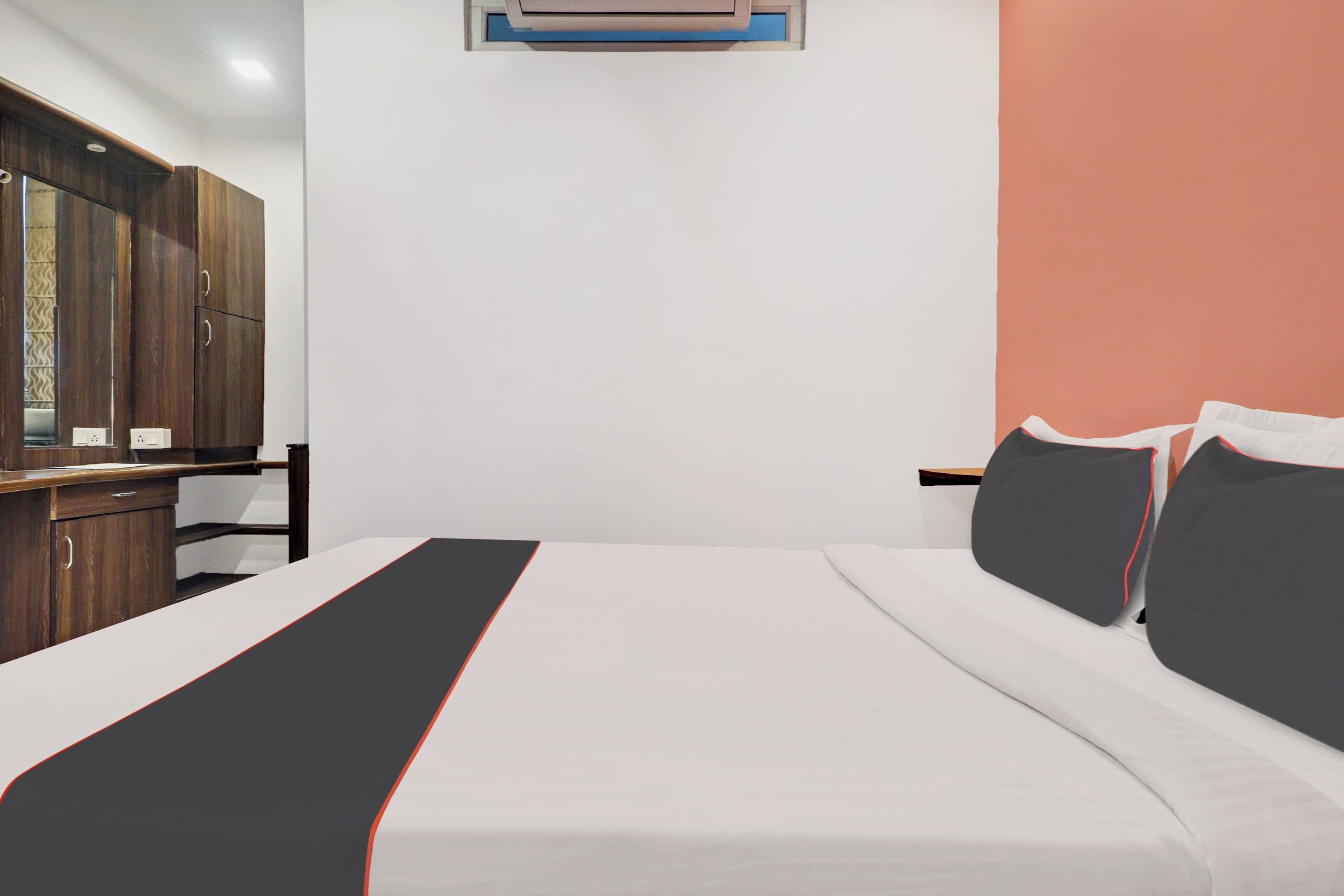 Une chambre d’hôtel avec un lit, un bureau et une armoire.
