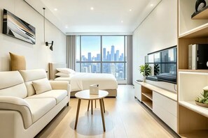 A modern hotel room with a city skyline view, a bed, a sofa, a small table, and a TV. - Meipeng (Shenzhen)