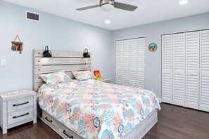 A bedroom with a bed, nightstands, a ceiling fan, and a set of white closets. - Longboat Key Condo with Beach Access - Pier Pressure (Longboat Key)