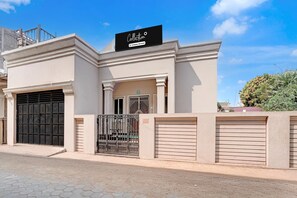 A building with a gated entrance, a signboard, and a clear sky. - Classic Puri Sea Side (Puri)