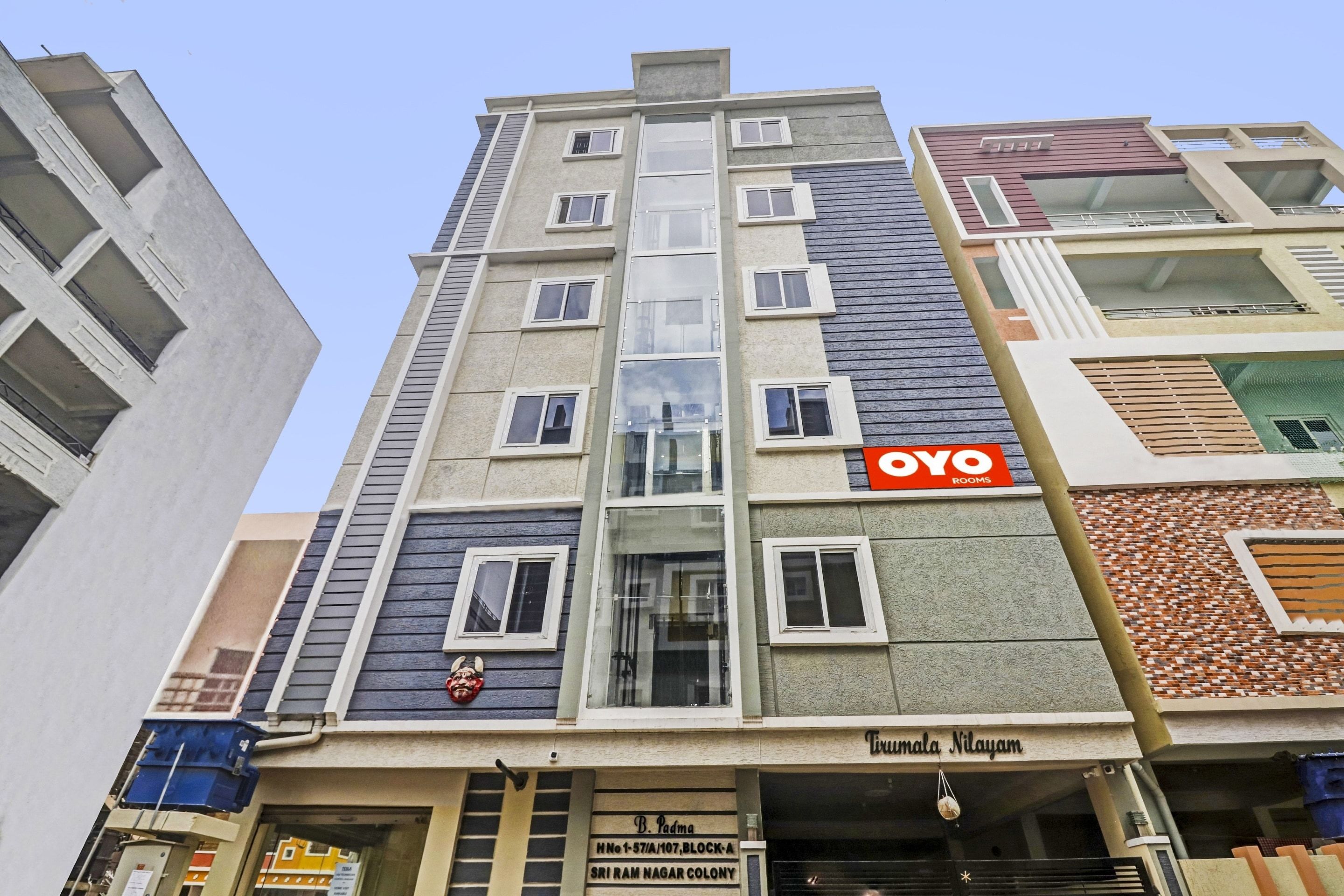 Ein mehrstöckiges Gebäude mit einem Schild für 'OYO Rooms' an der Fassade.