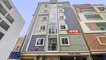 Ein mehrstöckiges Gebäude mit einem Schild für 'OYO Rooms' an der Fassade.