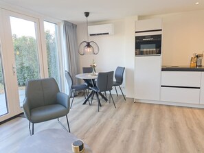 Eine moderne Küche mit weißen Schränken und einer schwarzen Arbeitsplatte.