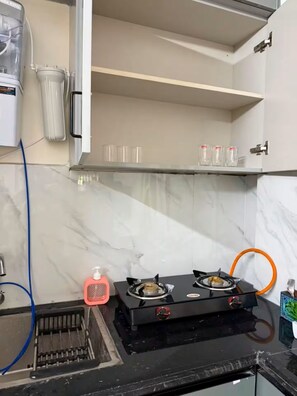 A kitchen with a gas stove, a sink, and a countertop. - Adorable 1-bedroom apartment in awesome Bengaluru neighborhood (Bengaluru)