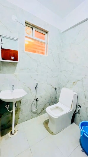 Ein Badezimmer mit Toilette, Waschbecken und Dusche.